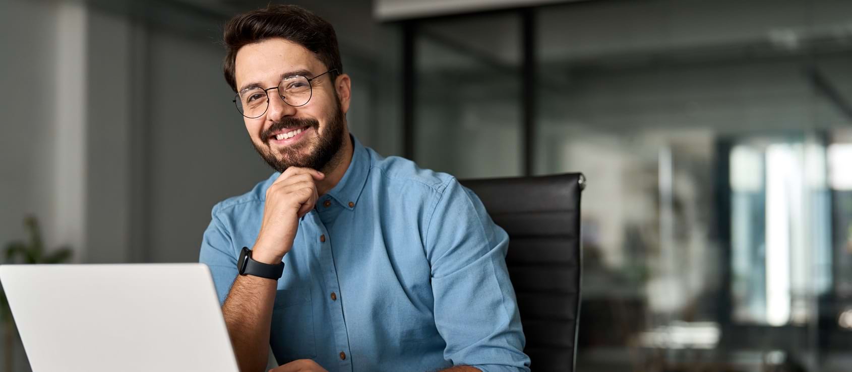 Portrait of happy professional business man looking at camera working in office.