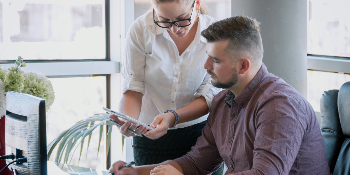 An administrative assistant working alongside a coworker, reflecting the importance of collaboration and communication in an Administrative and Accounts career in Kerry.