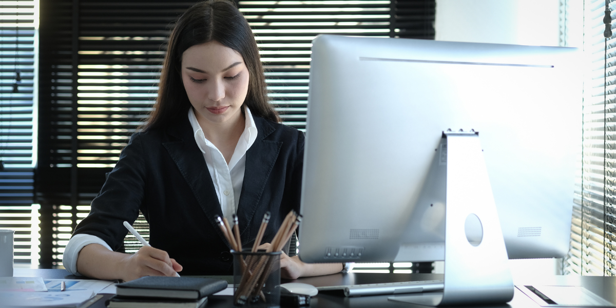 An accounts assistant focused on financial tasks at her computer, highlighting the essential skills for a thriving Administrative and Accounts career in Kerry.