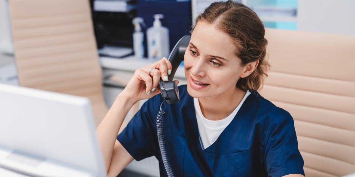 A professional Medical Secretary in Wexford smiling while assisting a patient over the phone, demonstrating strong communication and organisational skills. Explore Medical Secretary jobs in Wexford today.
