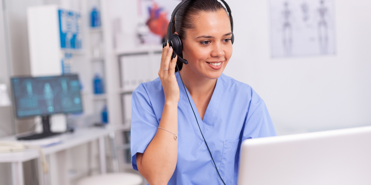 A friendly medical secretary having a positive conversation with a patient over the phone, highlighting the interpersonal and organizational skills needed to succeed in Waterford’s healthcare sector.