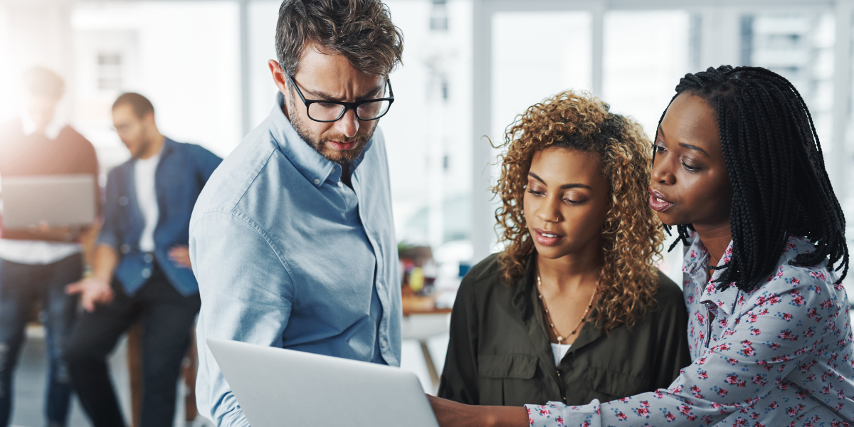 Three Office Support professionals collaborating on a solution, emphasizing teamwork and critical thinking. Get the skills to start your Office Support or Admin Career in Cork with Pitman Training.