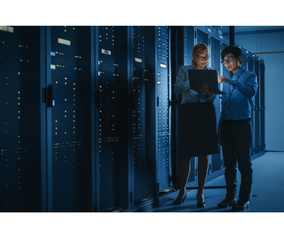 Two IT security engineers working on laptop in data centre server room during Pitman Training CompTIA Security+ diploma course