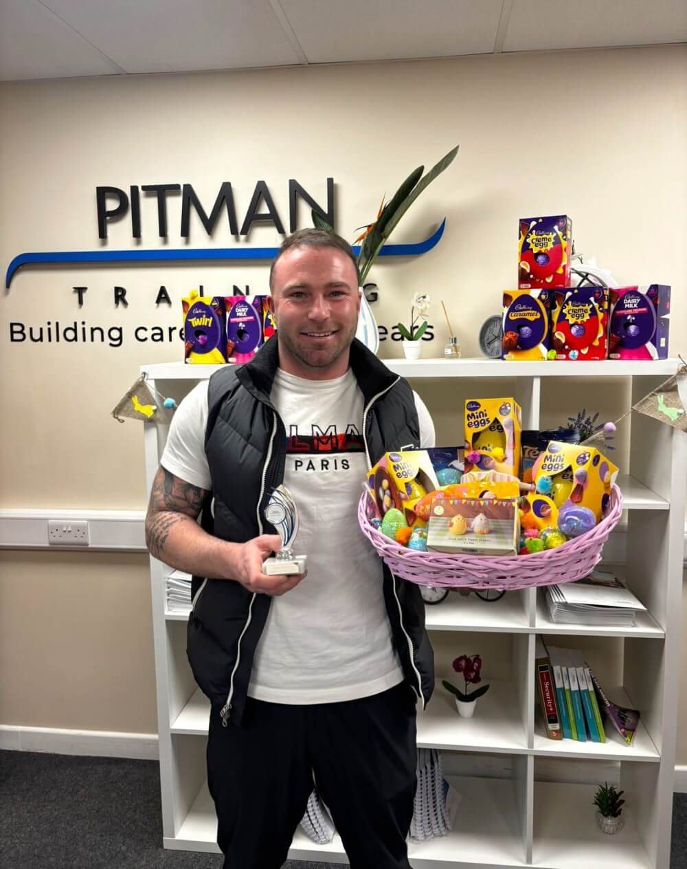 Student award winner at Pitman Training Cork holding trophy with Easter gift basket in training centre