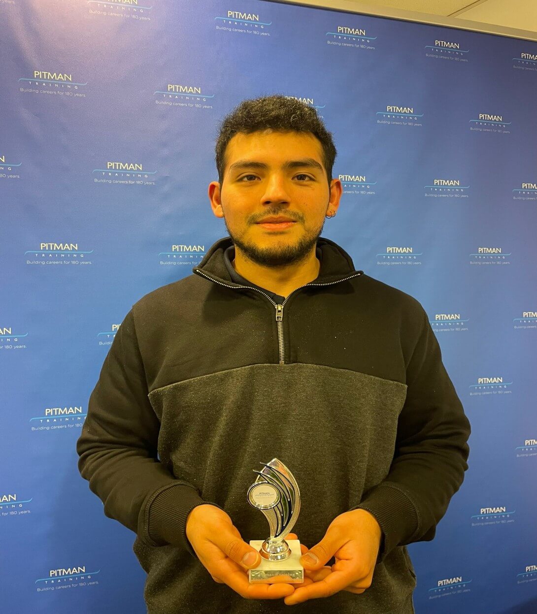 Student of the Month Bruno Juardo holding award at Pitman Training